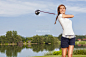 A girl teeing off playing golf on a course