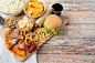 Fast food and unhealthy eating concept - close up of fast food snacks and coca cola drink on wooden table, stock photo