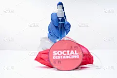 手在一个蓝色医用手套喷洒手部消毒液