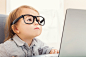 Smart toddler girl wearing big glasses while using her laptop by Justin Tierney on 500px