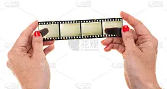 女性的手与红色指甲持有长35毫米的幻灯片在白色的背景