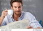 Morning portrait of handsome guy reading newspaper and holding coffee cup.