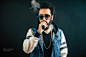 Young man with beard and sunglasses vaping an electronic cigarette. Smoke vaporizer