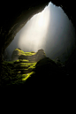 person on top of rock formation inside cave