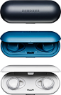 Gear IconX case that doubles as a charger in black along with a Gear IconX case that’s half open and with a pair of blue Gear IconX inside and a white Gear IconX case that’s fully open to reveal a pair of white Gear IconX inside the case that doubles as c