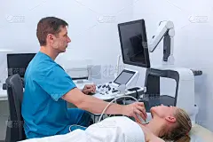 男医生使用超声波扫描仪检查病人的女性甲状腺。