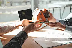 律师保险经纪人把房子模型送给顾客。 r