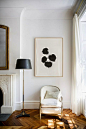 Living room, white chair, painting, black round lamp, light, fireplace, parquet floor