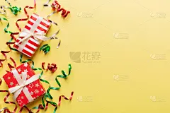 假日公寓里放着用五颜六色的纸包着的礼品盒，并用五彩纸屑装饰在彩色的背景上。圣诞节，生日，情人节和销售