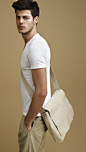 ...in neutral white shirt and beige pants, bag