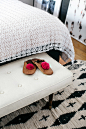 leather moroccan slippers with pom poms at foot of bed. / sfgirlbybay