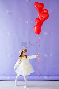 小女孩拿着心形的红色气球
