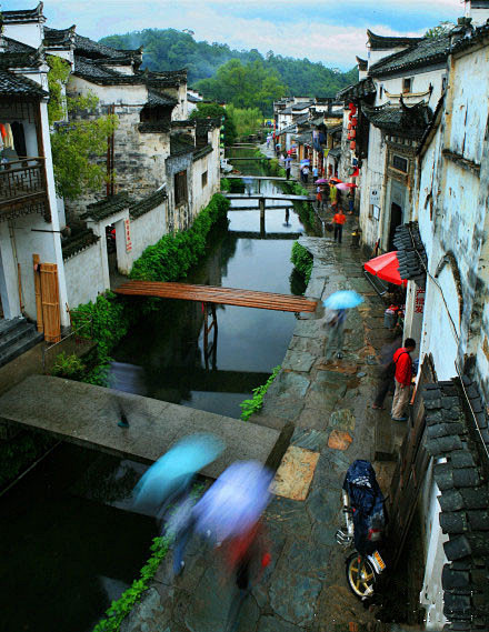 在细雨绵密中，撑起油纸伞漫步一条石板路，...