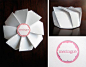 The origami-inspired cookie box emulates the folds and peaks of meringue cookies. Macaron boxes and bags frame the beauty and color of the macarons. Letterpressed tissue and seals add a pop of color and tactile quality to white and clear packaging.”: 