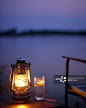 Zambia, Lower Zambezi National Park. Gin and tonic by light of a hurricane lamp looking out over the Zambezi River, Old Mondoro bushcamp.