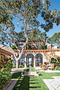 This Spanish Colonial–style home courtyard features hand-painted tilework around the arches.: