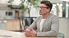 焦虑的中年男子坐着思考