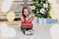 全身，前线模糊的照片，可爱的孩子坐在荷花的位置与圣诞礼物在手里，寻找里面是什么。图片-商业图片-正版原创图片下载购买-VEER图片库
