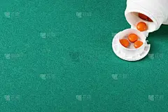 三片橙色药片，装在白色的外包装上。