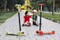 girls-sitting-push-scooters-walkway-park