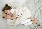 A cute little girl is sleeping in a bed with a Teddy bear toy . Concept of child development and sleep. The view from the top.