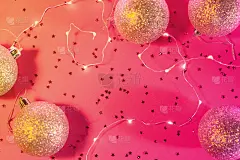 庆典用花环和球平躺在粉红色和橙色的霓虹渐变背景上