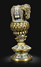 A CLOISONNÉ AND GILT-METAL ALTAR EMBLEM QING DYNASTY, QIANLONG PERIOD modelled in columnar form with an elephant standing four square on a double lotus base, all raised on a waisted circular platform enamelled with swirling waves and lotus lappets, sustai