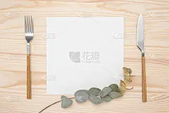 原型空白卡片和刀具在乡村木制背景。刀叉用白纸做菜单或食谱文字和金色桉树枝。木桌上平躺着食物菜单模型