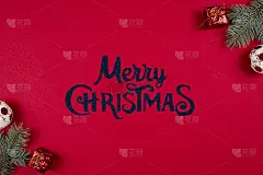 圣诞快乐字以红色为底色，杉木树枝和新年彩球围绕，平躺着