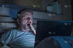 有吸引力的疲倦和压力的工作狂工作到深夜在床上忙着笔记本电脑打哈欠感觉困倦和在商业项目的期限压力概念过