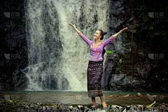 老挝妇女穿着老挝传统服饰享受与自然肖像概念，在瀑布。