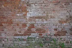 靠近旧的垃圾红色砖墙背景的纹理和细节