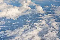 从商业飞机上看，下午的太阳照亮了蓬松的天空