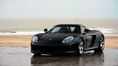 高清晰停靠在沙滩中的黑色保时捷卡雷拉GT（Carrera GT）壁纸下载图片