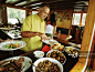 Man in galley of boat, putting food on plate from buffet table_创意图片