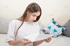 信中有大额付款发票。女孩在家里读一张纸，仔细地看课文