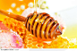 蜂蜜高清图片-滴在木棒和蜂巢上的金色透明蜂蜜