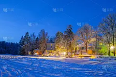 冰雪覆盖的冬天，在结冰的湖附近，照亮了小屋的景象
