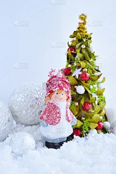 用节日装饰品装饰小女孩的身影和圣诞树Ð¾n雪。新年贺卡。