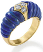 A lapis lazuli and diamond ring, by Cartier. The carved lapis lazuli set to the centre with brilliant-cut diamonds within an 18-carat gold lozenge-shaped plaque, ring size N, signed ‘Cartier London’, full UK import marks. Via Phillips.