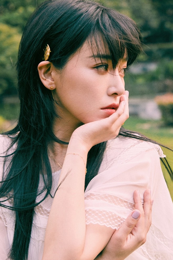 阚清子留着顺直长发她身穿超仙白色连体裙裤在竹林的背景下托腮对镜