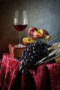 http://nikolay-panov.artistwebsites.com/products/peaches-and-grapes-nikolay-panov-art-print.html • Still life with glass of red wine, grapes, fresh peaches and old vantage books.