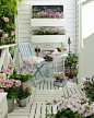 Give your patio space a shabby chic overhaul with white painted wood and plenty of floral displays: