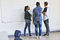 Multi-ethnic teenage students by whiteboard