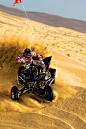 person riding on ATV and drift on sand