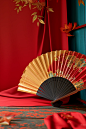 Golden fans and fans, red backdrop, and other decorations, in the style of vivid color blocks, fan ho, 3d, wrapped, neo-traditionalist, imitated material, trompe-l'oeil folds
