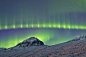 冰岛北极光壮观美景：绿紫相间似火焰

                　　作为最炫目、最壮观的自然奇观之一，北极光成为全球无数摄影师镜头追逐的目标。数年来，冰岛女摄影师乔尼娜-奥斯卡斯多蒂尔一直在致力于捕捉北极光现象，她以积雪覆盖的冰岛山脉为背景，拍摄了一系列美丽、壮观、震撼的北极光奇景。垂直的绿色和紫色北极光有如一团烧向夜空的火焰。                　　乔尼娜是冰岛东海岸六家卫生保健中心的护士长。她的工作让她有机会到处拍摄冰岛各地的北极光景象。乔尼娜表示，“......