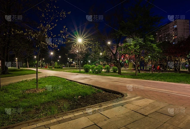 夜晚绿油油的公园里铺满了秋天的灯笼。公园里的长椅在春天的晚上。在晚上用灯笼照亮公园的道路。公园京都素材-花瓣网