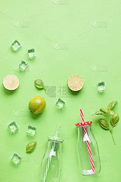 平铺的材料，夏季清凉饮料或冰沙，冰块，香草和玻璃罐在绿色背景，俯视图。草莓，酸橙，冰和罗勒是美味的夏