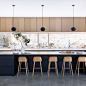 Kitchen - modern concrete floor and gray floor kitchen idea in Austin with flat-panel cabinets, light wood cabinets, window backsplash, stainless steel appliances, an island and white countertops